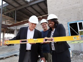Minister of Education Mitzie Hunter, right, checks a masonry level with Fred Alexander and mason Chris Lumsden, centre, of Contact Masonary during a tour of the new St. Teresa of Calcutta Catholic Elementary School Wednesday August 10, 2017.