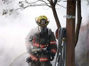 A Kingsville firefighter emerges from the smoke while attending a fire in the 600 block of Peter  Street. The blaze destroyed a shed and damaged part a family home in town.