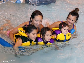 Camp councillors Megan Gregoire, back left, and Amanda Lafontaine assist young swimmers Carmella, left, Vivian and Avery, right, at the H2Oasis Aquatic Centre, part of Vollmer Culture and Recreation Complex on Aug. 25, 2017.