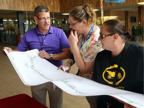 Open Streets Windsor project manager Michael Chanter, left, collaborates with Kayla Lessard and Gillian Benoit, right, of Ford City Hub during a community planning meeting at Windsor International Aquatic and Training Centre in late July. Open Streets Windsor runs Sept. 17, 2017.