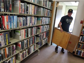 Volunteer Todd Howson removes flood-damaged furniture from Nilola Budimir Library August 30, 2017. The branch was closed due to flooding.