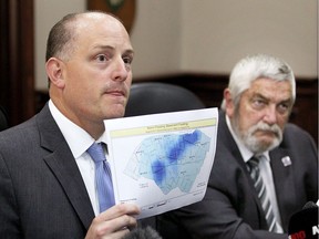 Windsor Mayor Drew Dilkens holds a map showing the pattern of flooded basements across Essex County after Tuesday's historic downpour. Lakeshore Mayor Tom Bain, right, joined Dilkens and Tecumeh Mayor Gary McNamara (not shown) to discuss this week weather event.