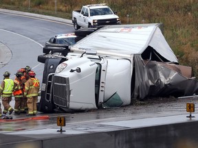 Tecumseh firefighters work the scene of a transport truck rollover on the westbound Highway 401 entrance near Howard Avenue in Windsor on Aug. 17, 2017. One person was taken to hospital with minor injuries.