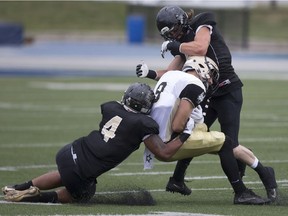 Windsor AKO Fratmen's Adam Chin, left, and Matt Chamberlain tackle  Edmonton's Conner Bergensen during the season opener between the AKO Fratmen and the Edmonton Huskies at Alumni Field, Saturday.  (DAX MELMER/Windsor Star)
Dax Melmer, Windsor Star