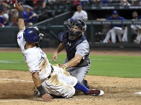 Detroit Tigers catcher John Hicks tags out Texas Rangers' Rougned Odor, left, at home plate as Odor tries to score on a single by Shin-Soo Choo in the eighth inning of a baseball game, Tuesday, Aug. 15, 2017, in Arlington, Texas. Texas won 10-4.