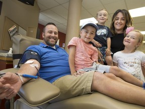 The Roehler family, from left, Kristopher, Lukas, 6, Max, 3, Lisa, and Emilia, 7, are pictured as Kristopher donates blood at the Blood Donor Clinic, Tuesday, August 8, 2017.  The Roehler family are holding an event at the clinic to share the memory of their late son, Christian, and honouring their son Lukas, both of which were diagnosed with a rare immune deficiency disorder.