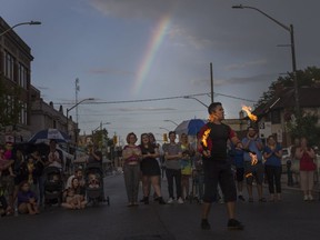 Daniel Craig of Street Circus performs for a large crowd at the Walkerville Buskerfest while a rainbow beams across the sky, Saturday, August 12, 2017.