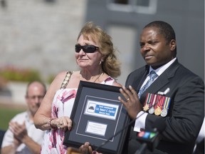 Elizabeth Anne Spencer, left, sister to Const. Robert Carrick, receives a memorial plaque from LaSalle Coun. Mike Akpata during a dedication ceremony on Aug. 20, 2017 for a tunnel on the Herb Gray Parkway that will be named after the Sandwich West police officer killed in the line of duty in August 1969.