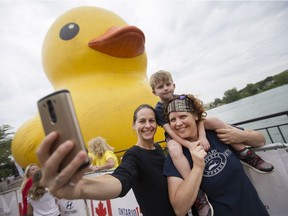 Kristina Gibson, left, and Tracey Hawksworth take a selfie with their son, Nate Gibson-Hawksworth, 4, in front of Mama Duck at the Canuck It Up! celebrations at the King's Navy Yard Park in Amherstburg, August 6, 2017.