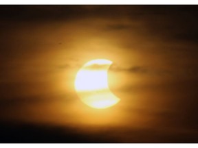 A partial eclipse is seen over Windsor on Thursday, October 23, 2014. The eclipse was visible until it dropped below the clouds in the evening sky.