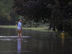 Zach Stephen wades through knee deep water on Everts Avenue in South Windsor after torrential rainfall on Aug. 29, 2017.