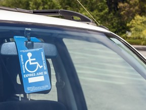 An accessible parking blue and white permit placard.