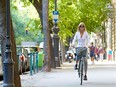 A woman cycles through a city.