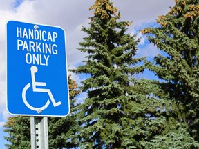 Handicap parking sign with trees in the background.