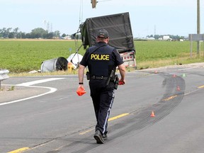 An Essex County OPP technical collision investigator examines the scene of a fatal crash involving a transport truck and a SUV on Highway 77 in Lakeshore on July 26, 2017.