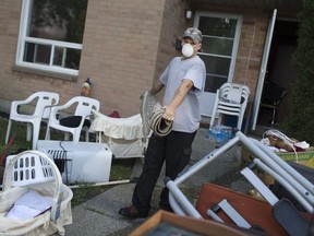 Ed Blake removes damaged items out of a unit at the Alix J. Sinkevitch Townhomes at 3380 Ypres Ave., Thursday, August 31, 2017.  The 36-unit complex has been without power since torrential rain caused massive flooding on Tuesday.