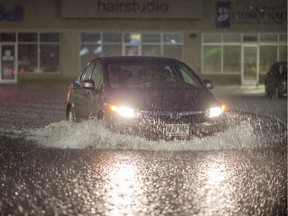 A car drives through a flooded parking lot outside of Sobey's in St. Clair Beach, Monday, August 28, 2017.