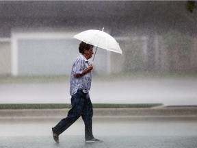 A pedestrian walks along Wyandotte Street East on Aug. 17, 2017, during a heavy downpour.