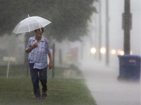 A pedestrian walks along Wyandotte Street East on Aug. 17, 2017, during a heavy downpour.