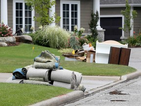 Flood-damaged carpeting and furniture sit on the curb of Chambers Drive near Patillo Road in Tecumseh on Aug. 29, 2017.