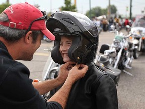 Paul Chenier (left) helps his daughter Emma with a motorcycle helmet before the 2011 Ride For the Breath of Life event in Windsor-Essex. Emma Chenier was diagnosed with cystic fibrosis when she was seven months old. The annual charitable motorcycle ride supports Cystic Fibrosis Canada.