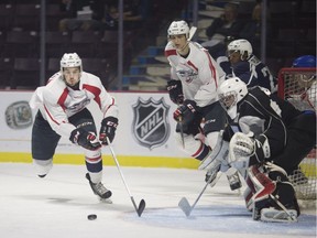 Windsor' Spitfires' defenceman Connor Corcoran, left, is seen playing the puck in front of the net in the white v. blue Spitfire game at the WFCU Centre in August.  (DAX MELMER/Windsor Star)