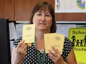Judy Allen, manager of the Healthy Schools program of the Windsor-Essex County Health Unit, holds personal immunization record booklets, in this September 2016 photo.