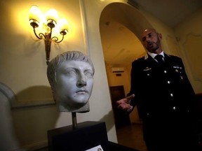 Italian Carabinieri officer Massimo Maresca shows the first century A.C. Druso marble head during an interview in the Carabinieri barracks, Friday, Sept. 1, 2017. The Cleveland Museum of Art gave it back to Italy after learning the piece depicting Emperor Tiberius‚Äô son had been stolen, apparently by Algerian troops, from southern Italy toward the end of World War II, brought into France, eventually sold at auction in Paris and acquired by the museum in 2012. (AP Photo/Alessandra Tarantino)
