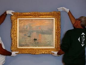 Employees remove Claude Monet&#039;s masterpiece &ampquot;Impression, Sunrise&ampquot; depicting his hometown of Le Havre, that&#039;s credited with spawning the word &ampquot;Impressionism&ampquot; , at Marmottan Museum, in Paris Wednesday Sept. 6, 2017. As part of an event celebrating 500 years since the birth of the town, &ampquot;Impression, Sunrise&ampquot; is going back to the French harbor town for the first time since it was painted there and is being lent exceptionally by a Paris museum to hang in Le Havre at the MuMa museum in Normandy until