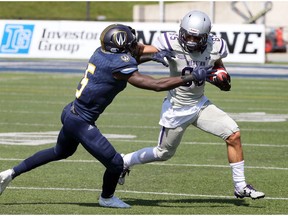 Western Mustangs receiver Malik Bessehieur, right, uses a stiff arm against Windsor Lancers Lekan Idowu in OUA action at University of Windsor Alumni Field on Sept. 16, 2017.