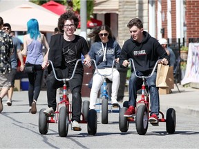Nate Blackton, 20, Ben Masse, 20, and Natalie Culmone, 19, ride adult tricycles during Dropped On Drouillard Festival September 16, 2017.