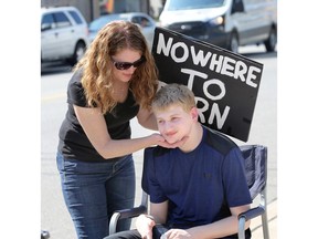 Barb Scott holds her son Matthew, 19, during a Parents of Adult Children with Disabilities Windsor/Essex protest at the Ontario Ministry of Community and Social Services office on Erie Street, Sept. 22, 2017.