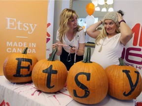 Sarah Fram, left, and Anissa Noakes, co-captains of Windsor Essex County ETSY Team, have fun with some merchandise during Windsor's first ETSY (Made-in-Canada) Craft Market at Mackenzie Hall Sept. 23, 2017.