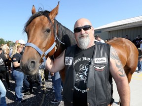Iron Horse Motorcycle Club member Chris 'Chillin' Hillman poses with a therapeutic riding horse during Windsor Essex Therapeutic Riding Association's annual Hogs for Horses fundraiser on North Malden Road in Essex September 24, 2017.
