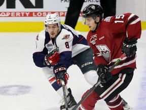 Connor Corcoran, left, of the Spitfires, checks Guelph Storm's Liam Hawell during OHL play last season. Guelph will be in Windsor on Sept. 20th for the Spitfires' home opener.