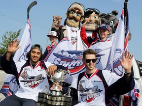 Windsor Spitfires Jalen Chatfield, left, and Austin McEneny, along with young fans, celebrate last year's Memorial Cup. With 14 new players on the roster, this year's team will require some patience early in the season.