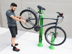 Oliver Swainson, mechanical education co-ordinator Bike Windsor/Essex, demonstrates how to use newly installed Dero Fixit bicycle repair station at Chisholm Branch of Windsor Public Library on Friday.