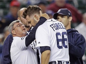 Pitcher Jeff Ferrell of the Detroit Tigers is examined by trainer Kevin Rand, left, and manager Brad Ausmus after getting hit in the head by a batted ball hit by Ryon Healy of the Oakland Athletics during the eighth inning at Comerica Park on Sept. 18, 2017 in Detroit.