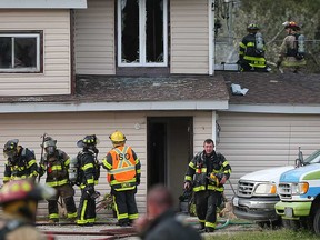 Firefighters rest after extinguishing flames at a home in the 6600 block of Baseline Road in Windsor on the evening of Sept. 11, 2017.