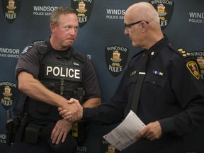 Windsor police Chief Al Frederick, right, congratulates Const. Kris Lauzon for receiving the the Governor General's Commendation for a 2015 rescue of a drowning man during a ceremony, Thursday, Sept. 14, 2017.