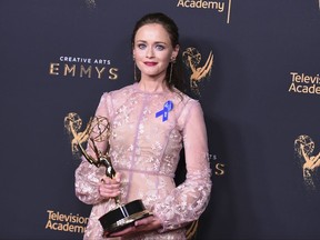 Alexis Bledel poses in the press room with the award for outstanding guest actress in a drama series for "The Handmaid's Tale" during night two of the Creative Arts Emmy Awards at the Microsoft Theater on Sunday, Sept. 10, 2017, in Los Angeles. (Photo by Richard Shotwell/Invision/AP)