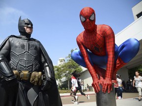 FILE - In this July 23, 2016 file photo, Dorian Black, left, dressed as Batman and Kyle Blankenfield, dressed as Spider-Man appear outside during Comic-Con International in San Diego. A court battle between two rival pop-culture conventions in California and Utah is marching on with a judge's refusal to toss out the case over rights to the phrase "comic con." U.S. District Judge Anthony Battaglia made a split decision Tuesday, Sept. 12, 2017, in the case that started when the well-known San Diego Comic-Con sued upstart rivals in Salt Lake City for trademark violation.