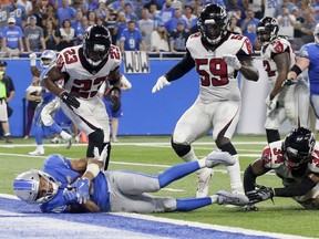 Detroit Lions wide receiver Golden Tate, bottom left, falls into the end zone for a one-yard touchdown reception during the second half of an NFL football game against the Atlanta Falcons, Sept. 24, 2017, in Detroit. The replay official reviewed the score ruling and the play was reversed.