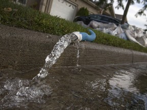 Water is pumped out of a Tecumseh residence after torrential rains flooded area homes in this Oct. 2, 2016 photo.