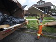 Anita Salamone, a driver/loader with Miller Waste Systems out of Toronto, loads flood refuse into a garbage truck on Arthur Road on Sept. 13, 2017.