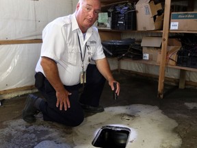 Building inspector Dwayne Kenney uncovers a backflow valve at a Windsor home on Sept. 20, 2017.