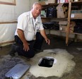 Building inspector Dwayne Kenney uncovers a backflow valve at a Windsor home on Sept. 20, 2017.