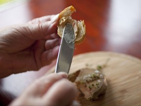 FILE - This July 17, 2012, file photo shows Karlene Bley of Los Angeles spread her torchon of foie gras onto bread during lunch at the Presidio Social Club restaurant in San Francisco. A federal appeals court reinstated California's ban on foie gras Friday, Sept. 15, 2017, finding that a state law preventing sales of the luxury liver pate made by force-feeding ducks and geese was not pre-empted by the federal government's authority to regulate poultry products. (AP Photo/Eric Risberg, File)