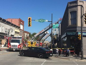 Downtown Leamington business owners and residents watch as firefighters use aerial ladder trucks to deal with an apartment fire on Erie Street on Sept. 15, 2017.