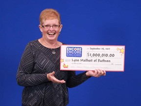 Lynn Mailhoit of Ruthven holds up the $1,000,010 cheque she received from the OLG thanks to adding ENCORE to a Lottario ticket.